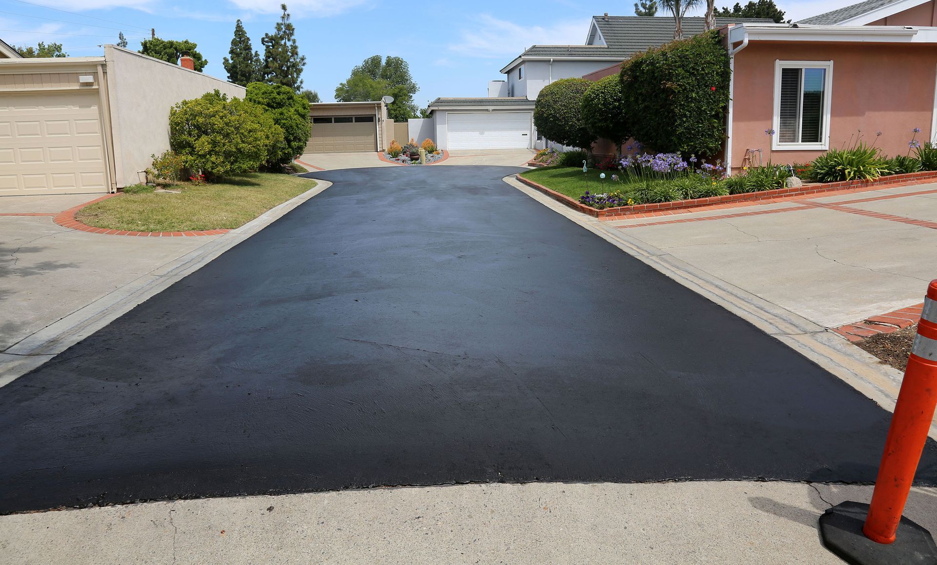 Newly paved blacktop driveway leading up to a residential home